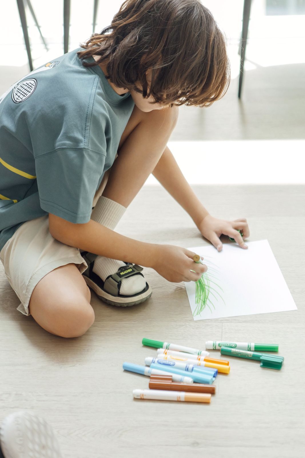 طفل صغير يرسم بأقلام ملوّنة في جلسة Kidsology