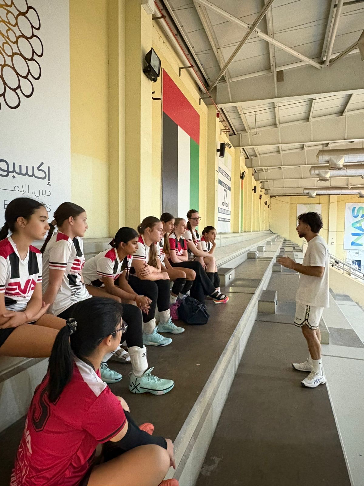 Young athletes at a Kidsology session in Dubai, listening to a coach before training